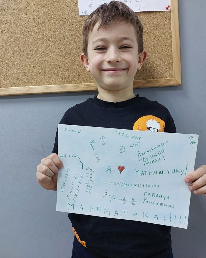 Ученик с плакатом «Я люблю математику»